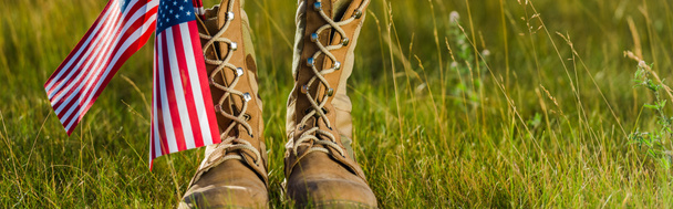 panoramic shot of military boots near american flag with stars and stripes on grass  - Valokuva, kuva