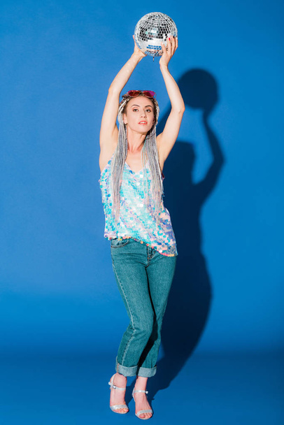 beautiful fashionable girl posing with disco ball on blue  - Zdjęcie, obraz