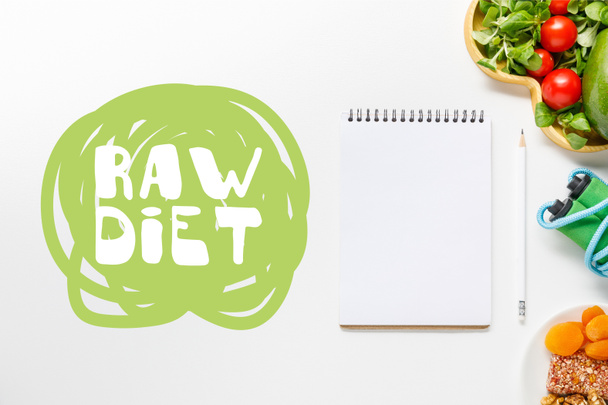 top view of blank notebook near diet food and skipping rope on white background with with raw diet lettering - Photo, Image