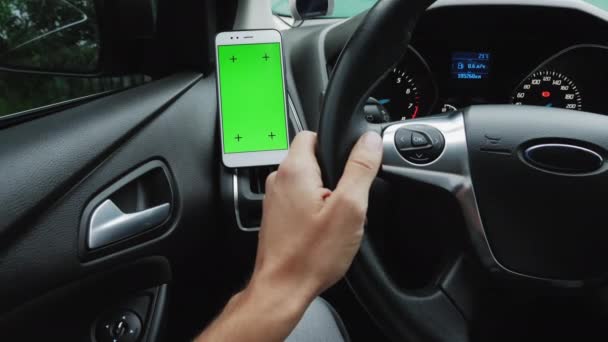 Korzystanie ze smartfona w samochodzie z zielonym monitorem ekranu - Materiał filmowy, wideo
