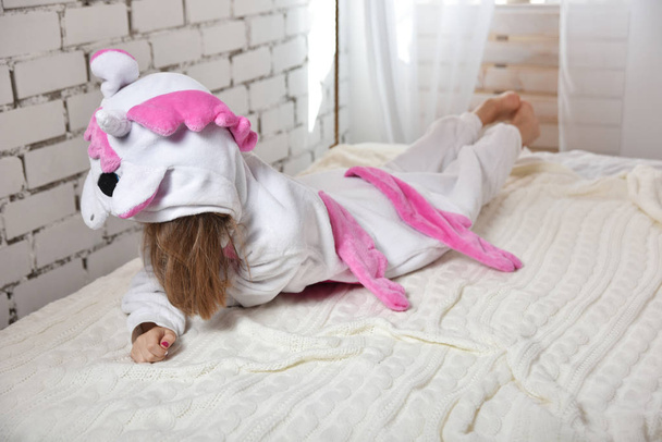 aranyos lány egy rózsaszín és fehér parókát az egyszarvú pizsama jelmez - Fotó, kép