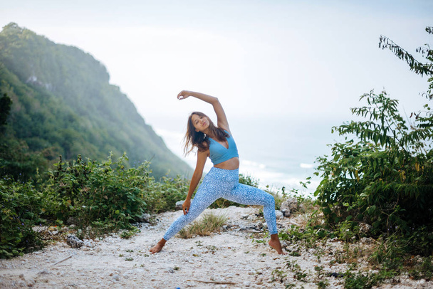 Meisje praktijk yoga in de buurt van Oceaan. - Foto, afbeelding