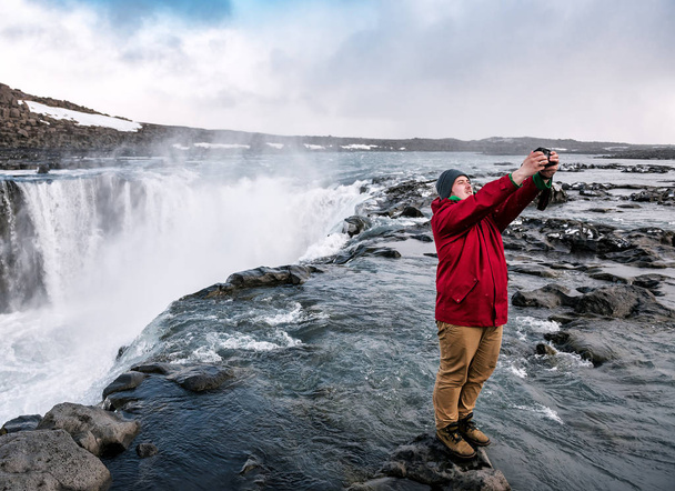 homme prend un selfie sur le fond d'une cascade - Photo, image