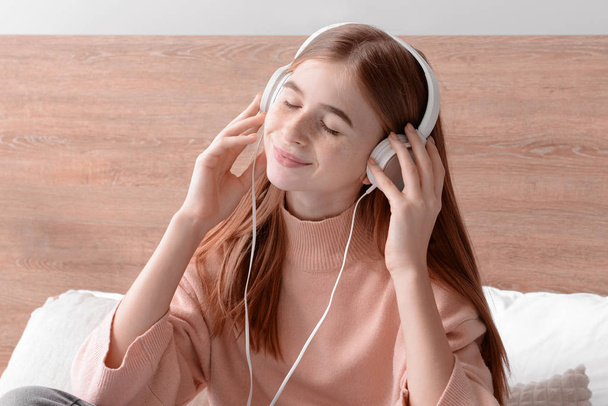 Linda adolescente escuchando música en el dormitorio en casa
 - Foto, Imagen