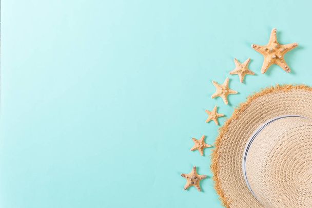 Beach hat with seashells on brown blue table. summer background concept with copy space top view - 写真・画像