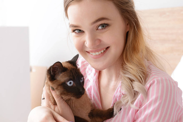 Yatak odasında sevimli Tay kedi ile genç kadın - Fotoğraf, Görsel