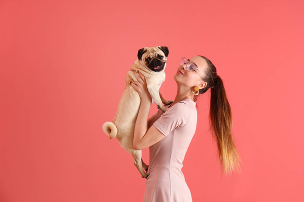 Teenage girl with cute pug dog on color background - Φωτογραφία, εικόνα
