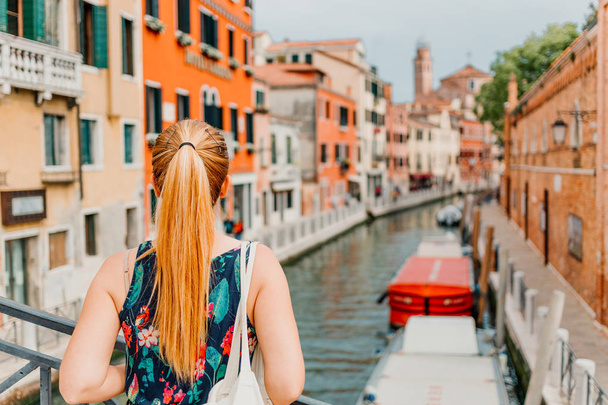 Młoda kobieta stoi na moście w Wenecji, Włochy ciesząc się widokiem - Zdjęcie, obraz