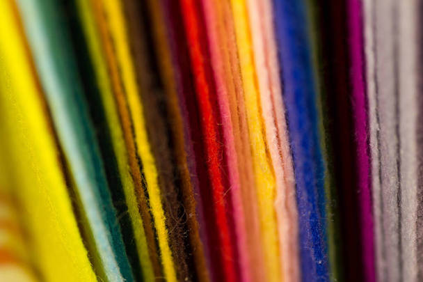 blurred vertical bright color stripes stack of felt sheets selective focus macro fibers texture of felt background  - Foto, afbeelding