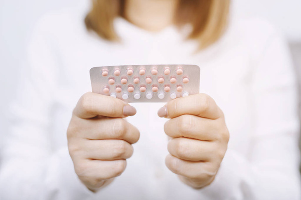 La donna ha in mano le pillole anticoncezionali. mangiare pillola contraccettiva. La contraccezione riduce il parto e il concetto di gravidanza
. - Foto, immagini
