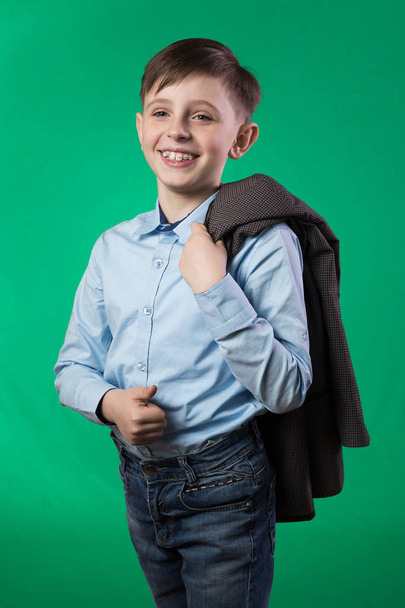 Schoolboy posing on a green background - Foto, Imagen