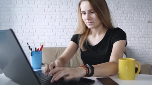 Портрет красивої молодої кавказької дівчини, яка друкує на ноутбуці, уважно сидить вдома. Близько. Концепція позаштатна робота, бізнес, комунікація, навчання
. - Кадри, відео