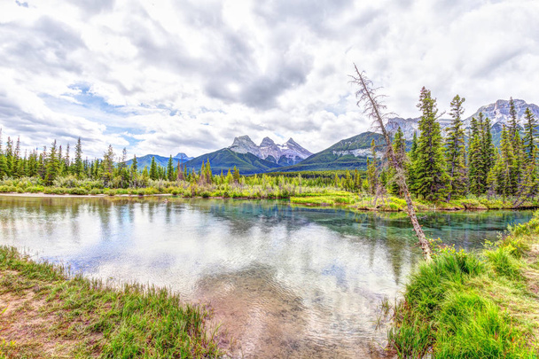 Canmore's Three Sisters mountain peaks at Policeman Creek in the - Фото, изображение