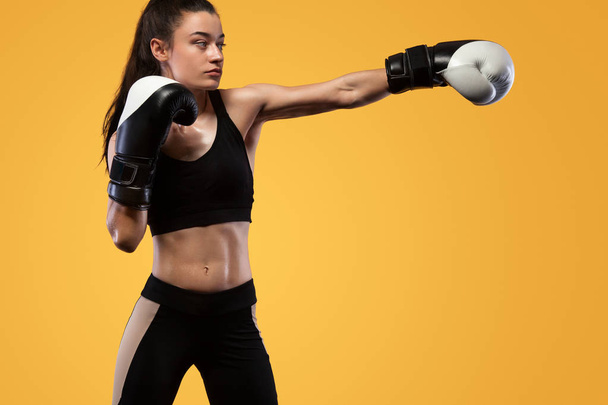Sportsman, woman boxer fighting in gloves. on yellow background. Boxing and fitness concept. - Foto, imagen
