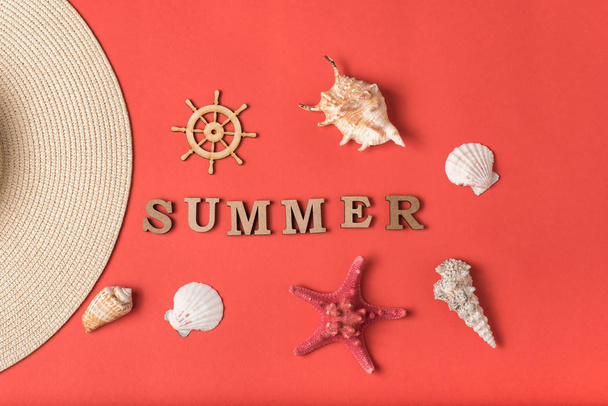 Palabra de verano de letras de madera. Conchas de mar, parte de un sombrero y volante. Fondo coral vivo. Acostado. Concepto marino
 - Foto, imagen