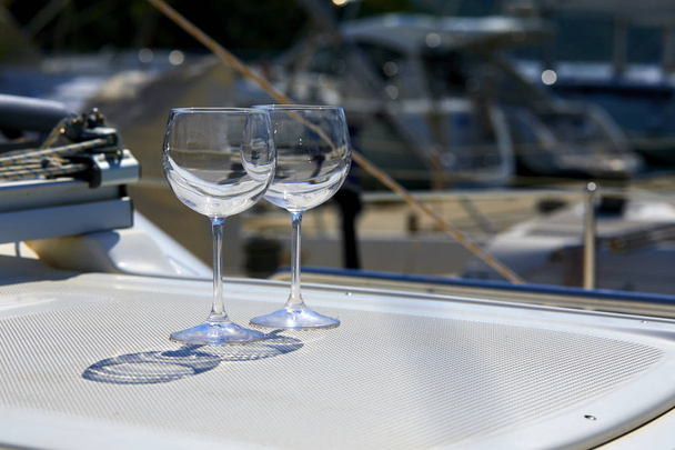 Pair of empty transparent wineglasses on yacht - Photo, Image