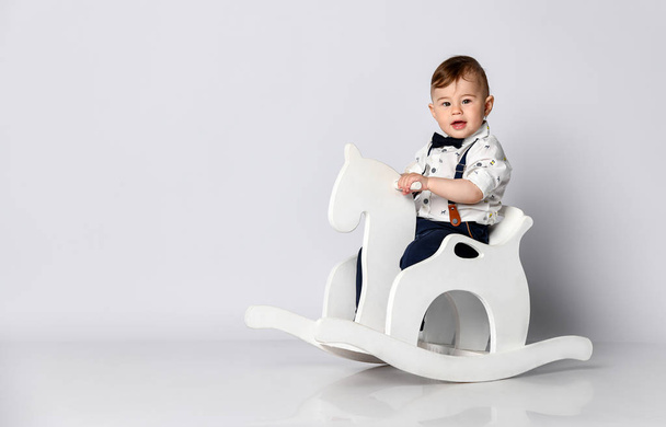 Funny baby sitting on the toy horse - Фото, зображення