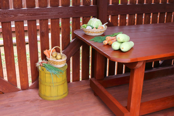 木製の小屋のテーブルの上の異なる新鮮な野菜. - 写真・画像