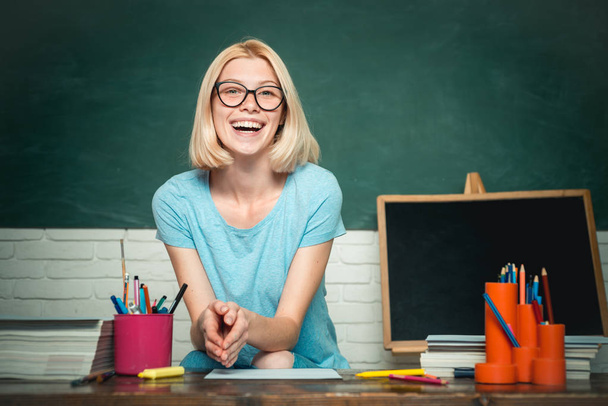 Portrait of creative young smiling female Student in glasses. Smiling girl student or woman teacher portrait on green wall blackboard background. Thank You Teacher. - 写真・画像