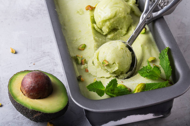Homemade organic avocado and mint ice cream in a metallic container, close up shot - Fotó, kép