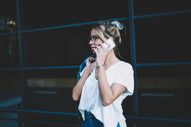 Young beautiful hipster girl calling to operator for consultancy about international conversations in roaming, attractive woman talking with colleague from work using good 4g internet on cellphone - Fotoğraf, Görsel