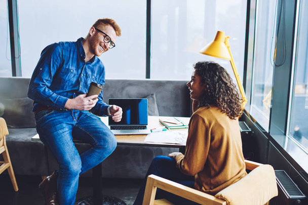 Cheerful excited male and female colleagues enjoying coffee break during cooperation in coworking space, happy successful man and woman laughing from joke togetherness, concept of friendship - Foto, Bild