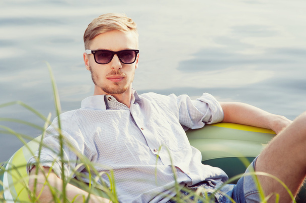 Young man resting in boat - Fotoğraf, Görsel