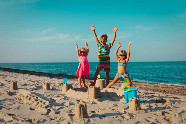 щасливі діти хлопчик і дівчатка грають з піском на пляжі
 - Фото, зображення