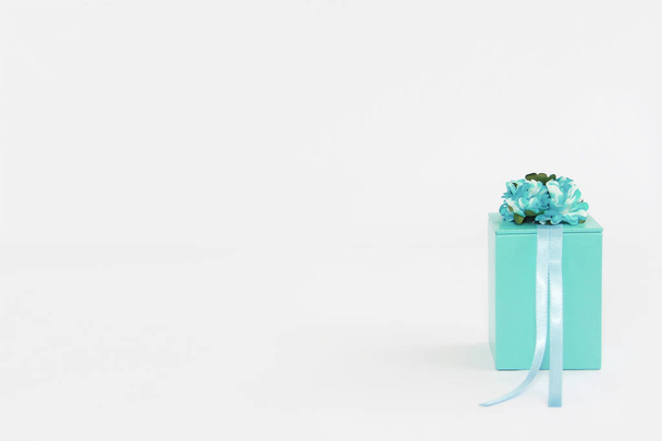 Decorative blue gift box with flower and ribbon designs - 写真・画像
