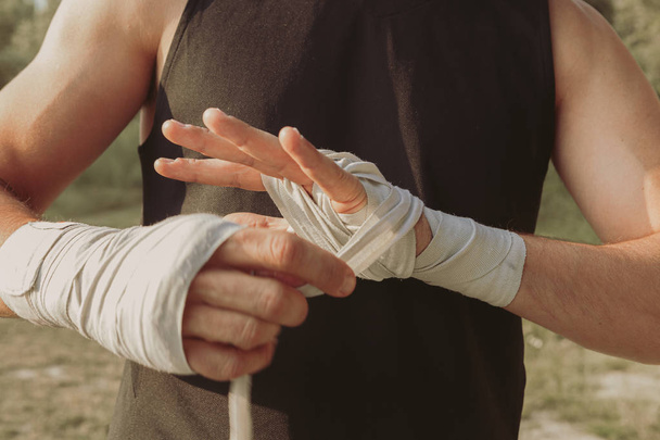 bir atlet boks bandaj ile ellerini sarma eğitim için kendini hazırlar - Fotoğraf, Görsel