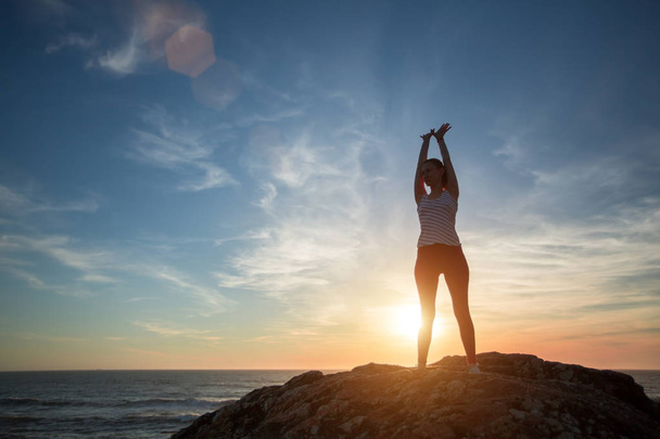 Silhouette Fitness Yoga-Mädchen auf dem Hintergrund des Meeres Morgenübungen trifft die Morgendämmerung. Gesunder Lebensstil.  - Foto, Bild