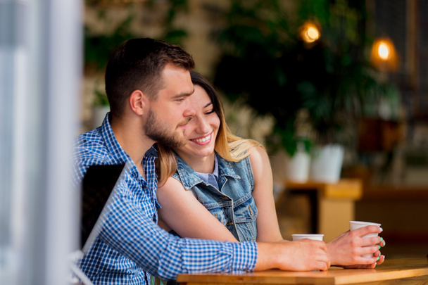 pareja joven sentada en una mesa en un café y tomando café
 - Foto, Imagen