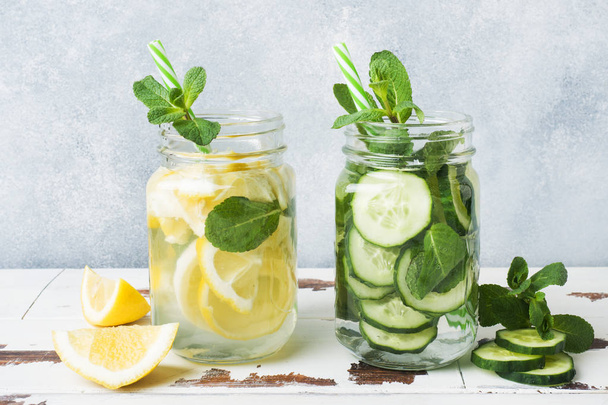 Detox water for healthy lifestyle. Fresh water in jar with lemon, cucumber and mint on wooden table. - Fotó, kép