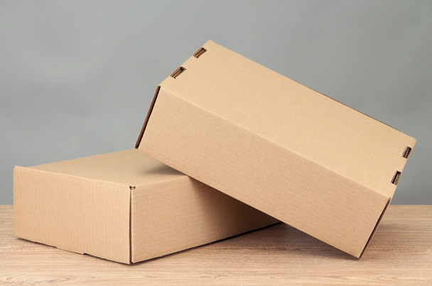 Parcels boxes on wooden table, on grey background - Fotografie, Obrázek