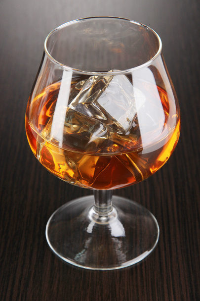 Brandy glass with ice on wooden background - Photo, Image