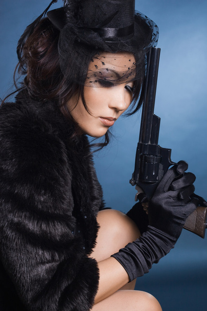 Elegant lady with a pistol in hands - Фото, зображення