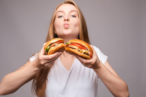 Голодная девушка кусает бургер.Бургер с курицей и салатом
 - Фото, изображение