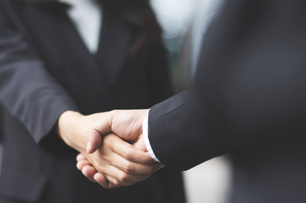 Closeup of a businessman hand shake businesswoman between two colleagues OK, succeed in business Holding hands. - Фото, зображення