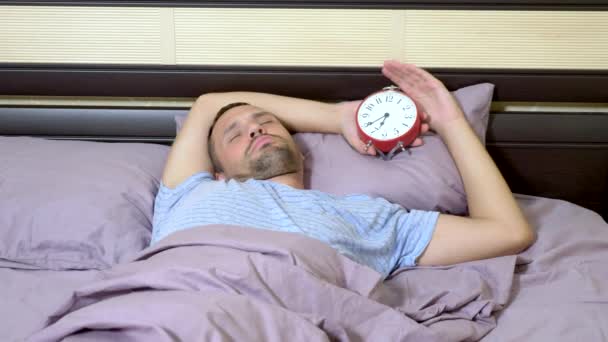 the guy wakes up and is angry that the alarm clock has rung. - Séquence, vidéo