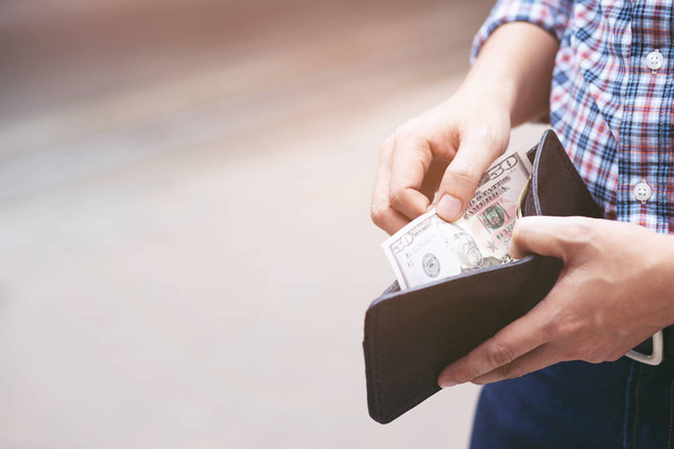 Biznesmen osoba posiadająca portfel w rękach mężczyzny wziąć pieniądze z kieszeni. - Zdjęcie, obraz