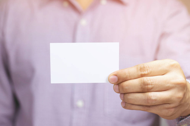 El hombre de la gente sostiene las tarjetas de visita muestran la maqueta de la tarjeta blanca en blanco. o portapapeles tarjeta de crédito nombre pantalla frontal. Concepto de marca empresarial
. - Foto, imagen
