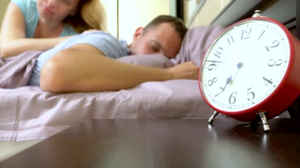朝のベッドで眠いカップルは目を覚まして、アラームをオフにすることはできません - 映像、動画