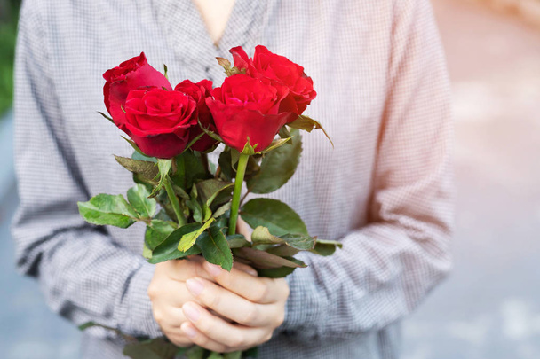 νεαρή γυναίκα δύο χέρια κρατώντας κόκκινο τριαντάφυλλο λουλούδι φύση όμορφα λουλούδια με άδεια αντίγραφο χώρος κενό γράφουν μηνύματα στην ημέρα του Αγίου Βαλεντίνου, γάμου ή ρομαντική αγάπη έννοια. - Φωτογραφία, εικόνα