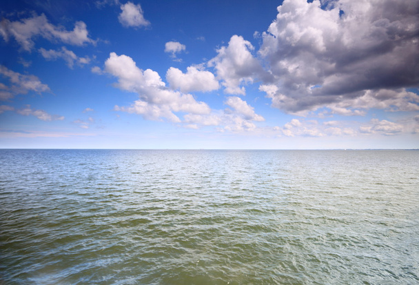 Bulutlu mavi gökyüzü denizin yüzeyinde - Fotoğraf, Görsel