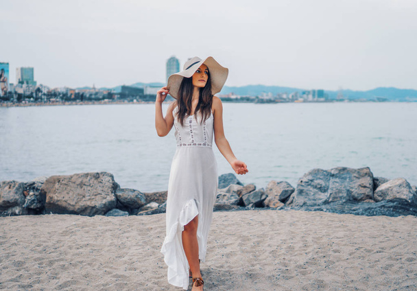 Beyaz elbise ve pamela şapka ayakta giyen güzel kadın - Fotoğraf, Görsel
