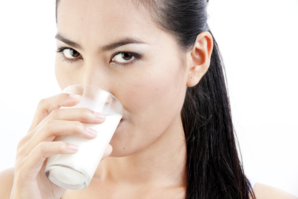 Woman drinking milk. Happy and smiling beautiful young woman enjoying a glass milk. - Foto, immagini