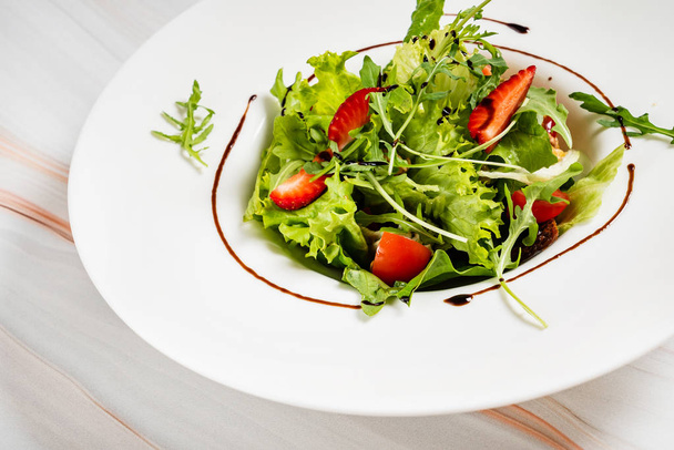 healthy salad with strawberriesa and arugula, close up - Photo, image