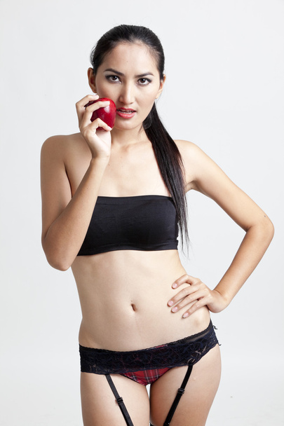 Shot of a sexy woman in black hand holding red apple - Fotoğraf, Görsel