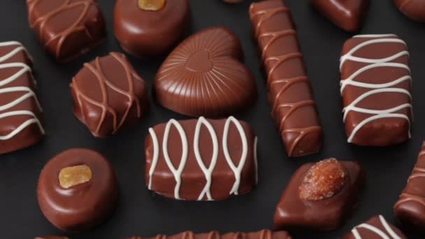Closeup of different chocolates in golden box rotates - Кадри, відео