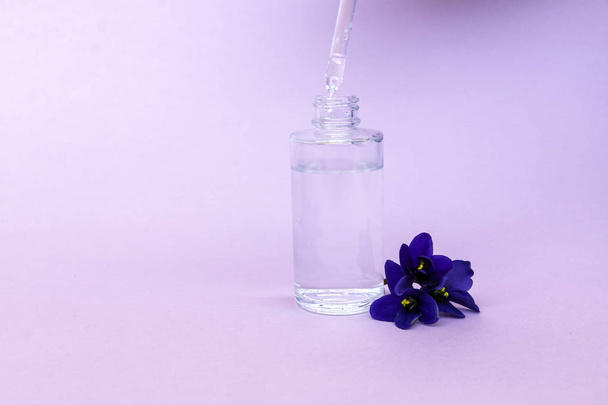 liquid in  transparent bottle with pipette for soaring electronic cigarettes with  scent and taste of flowers, on  pink background with space for text. - Fotoğraf, Görsel